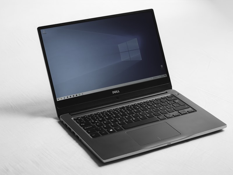 A silver business laptop, open, on a plain white surface.